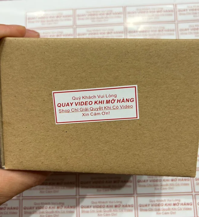 Tem chữ đỏ nền trắng được dán trên hộp giấy kraft